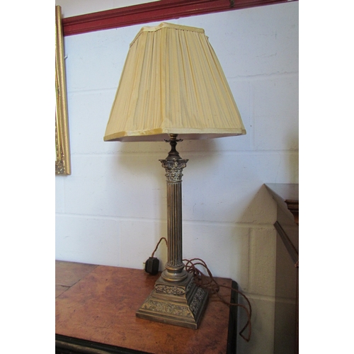 1018 - A brass Corinthian column table lamp with mask detail to base and pleated gold coloured shade