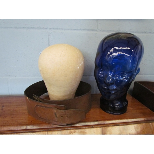 1070 - Two display heads, one cloth and the other blue glass together with a leather belt