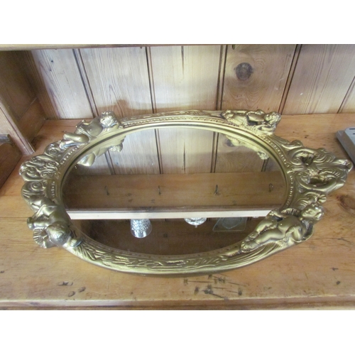 1075 - A gilt and gesso framed mirror decorated with Cherubs