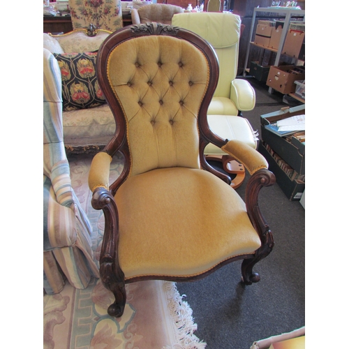 1133 - A Victorian mahogany spoon back armchair, buttoned velour upholstery, on scroll feet to castors   (E... 