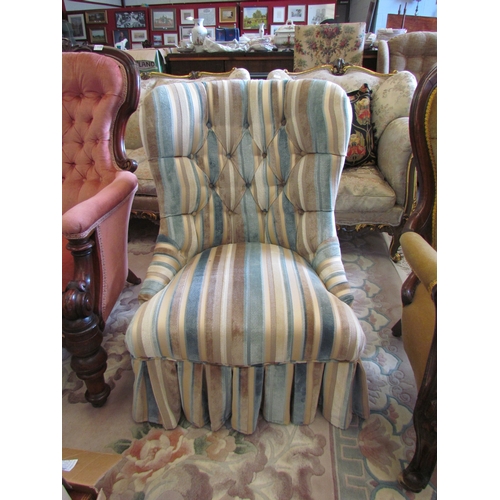 1134 - A Victorian style button-back armchair with pleated skirt on turned and tapering fore legs   (R) £45