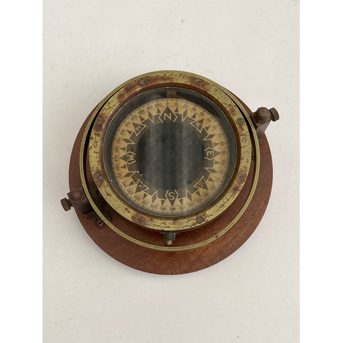 8031 - A brass cased gimballed compass, no visible maker, mounted on hardwood plinth, 13cm diameter case