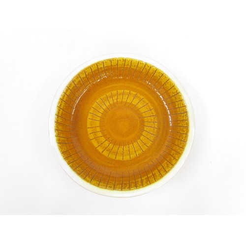 7015 - An Italian Bitossi style bowl, mustard glaze with indistinct 'Italy' marks to base. 23.5cm diameter ... 