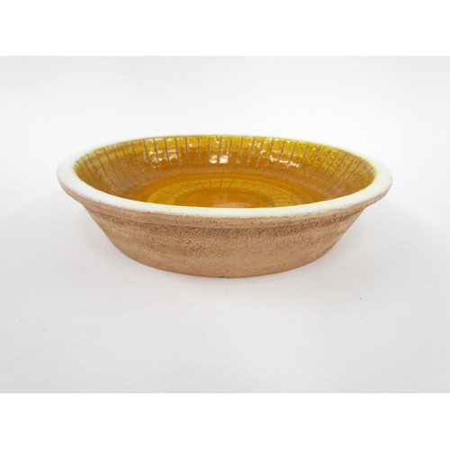 7015 - An Italian Bitossi style bowl, mustard glaze with indistinct 'Italy' marks to base. 23.5cm diameter ... 