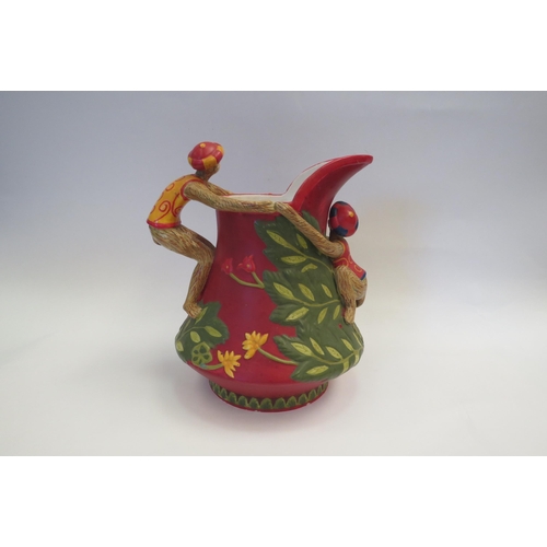 1001 - A figural matte glazed jug with a monkey form handle and floral decoration , 25cm high