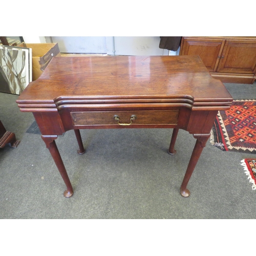 1084 - A George III mahogany games table, the double fold-over top, over a concave frieze set with single d... 