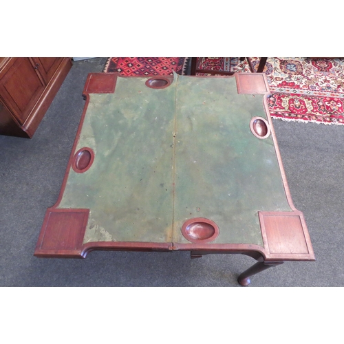 1084 - A George III mahogany games table, the double fold-over top, over a concave frieze set with single d... 