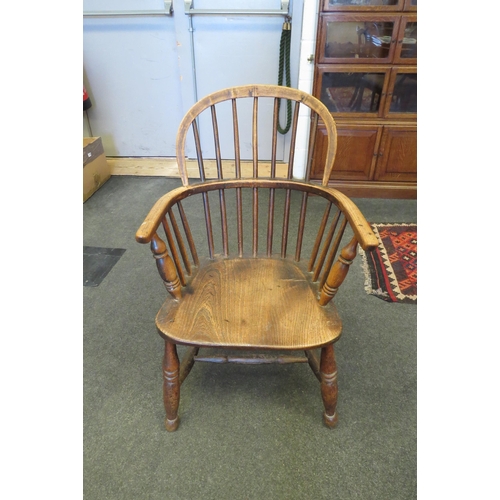 1094 - An elm seated Windsor hoop-back country chair, on turned supports joined by a stretcher