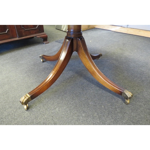 1097 - A circular top table on outswept legs with brass lion paw feet on brass cup castors   (R) £15