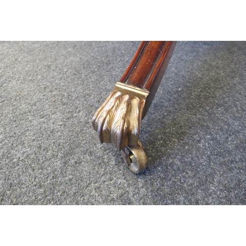 1097 - A circular top table on outswept legs with brass lion paw feet on brass cup castors   (R) £15