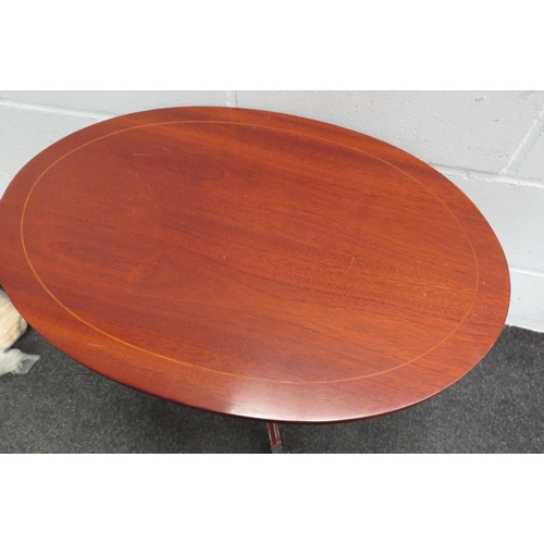 1105 - An oval top table on outswept legs with lion paw feet and castors together with an oval dressing tab... 