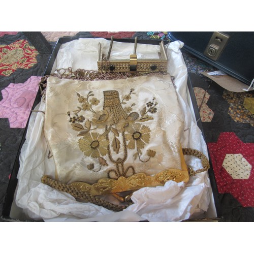 6061 - A suitcase containing two wool tablecloths, a crewelwork style textile, a piece of vintage gold lame... 