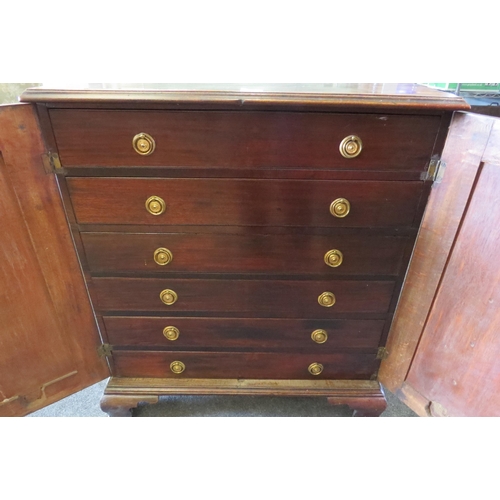 1498 - A 19th Century mahogany cabinet, the two doors opening to reveal six drawers, raised on ogee bracket... 