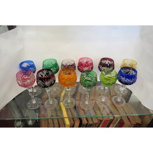 1438 - A group of twelve crystal coloured hock glasses one with Kirkstall Lausitzer Elias label to base