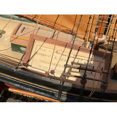 8013 - A model of a fishing smack, red and black hull with gilt band, marked ‘Essex’, plaque with provenanc... 