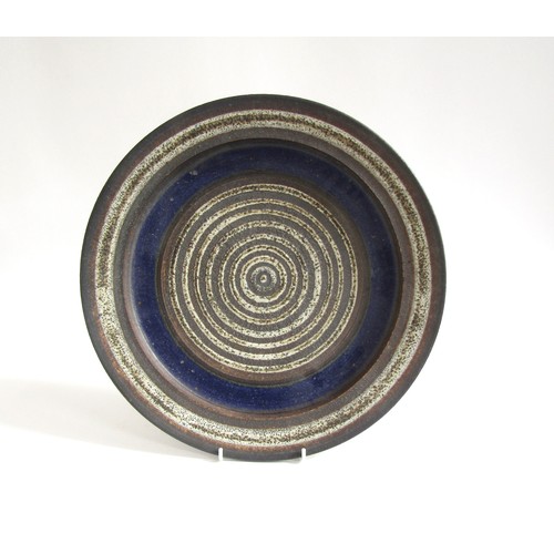 7070 - ROBIN WELCH (1936-2019) A studio pottery charger, deep blue and off-white, impressed mark underneath... 