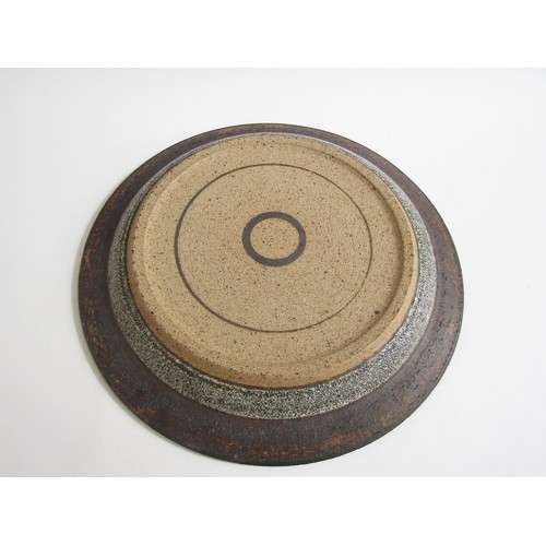 7070 - ROBIN WELCH (1936-2019) A studio pottery charger, deep blue and off-white, impressed mark underneath... 