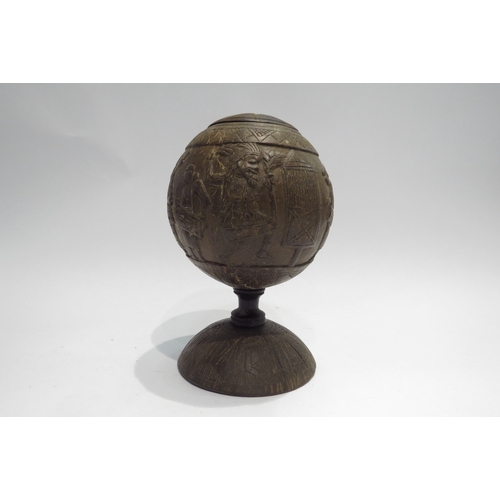 4427 - A carved coconut shell decorated with tribal scenes, lidded, 20cm tall  (R)  £40