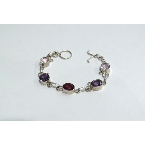 4422A - A silver bracelet with pink, purple and red gem stones