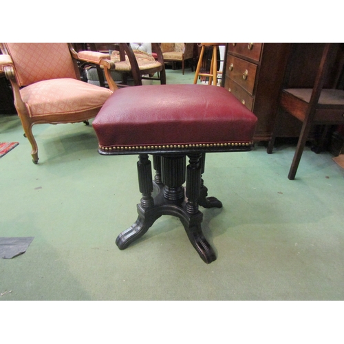 4011 - A late Victorian ebonised revolving and height adjustable piano stool, the square seat on reeded col... 