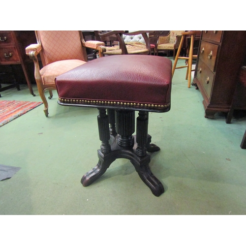 4011 - A late Victorian ebonised revolving and height adjustable piano stool, the square seat on reeded col... 