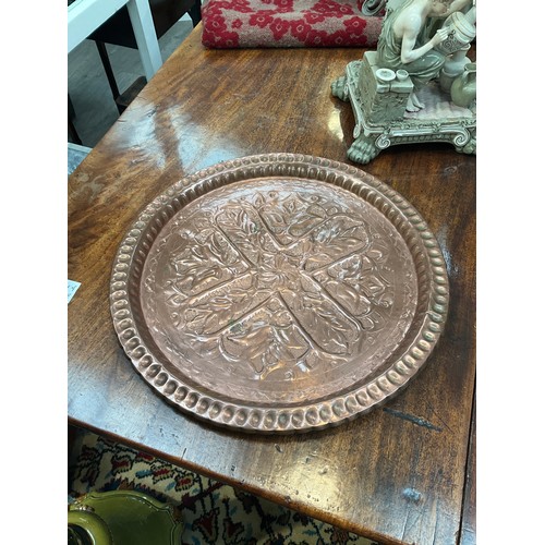 4114 - An Arts & Crafts copper tray with floral cross detail, 38.5cm diameter