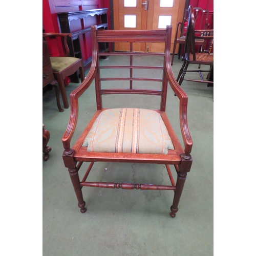 4180 - In the manner of 'Heals London' a walnut Arts & Crafts armchair with cross rail back rest and drop-i... 