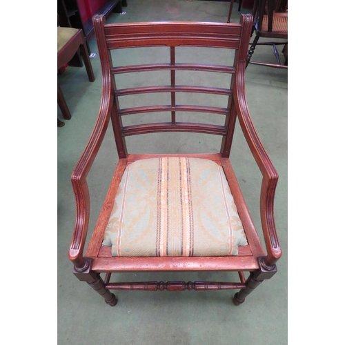 4180 - In the manner of 'Heals London' a walnut Arts & Crafts armchair with cross rail back rest and drop-i... 