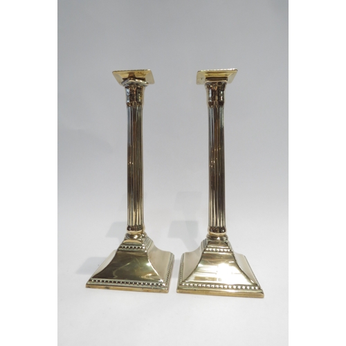 4193 - A pair of early 19th Century metal column candlesticks with maker's initials to base, 27cm tall     ... 