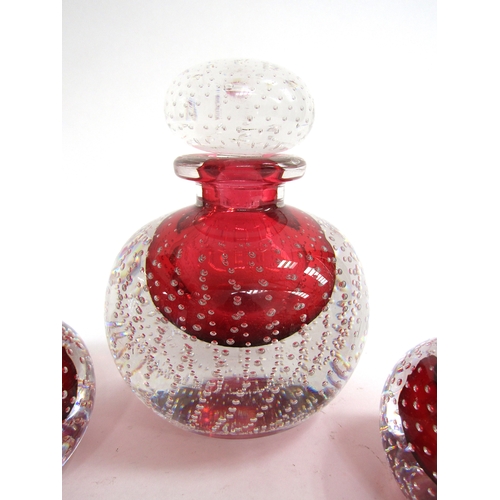 7156 - A large red glass globular bottle and stopper with controlled bubble detail, 15cm high, broken ponti... 