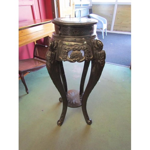 4029 - An Oriental heavily carved ebonised jardiniere stand with under-tier, 92cm tall