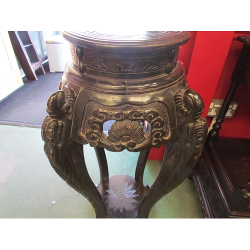 4029 - An Oriental heavily carved ebonised jardiniere stand with under-tier, 92cm tall