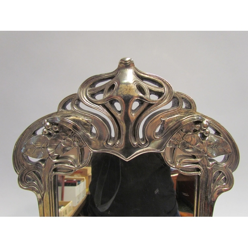 4068 - An Art Nouveau style metallic effect easel-back table mirror, the base with relief of reclining semi... 