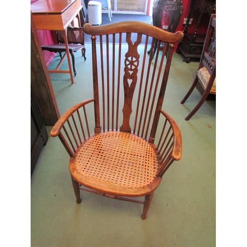 4074 - An early 20th Century wheel back Windsor chair, bergere seated, turned spindle supports