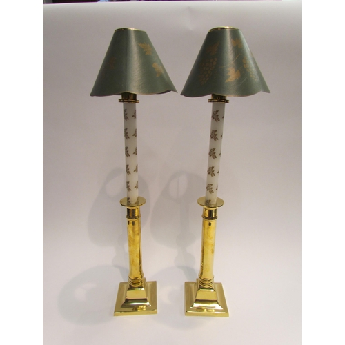 4106 - A pair of brass based candlesticks with holly design