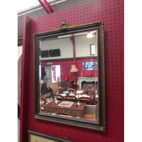 4127 - A gilt and ebonised framed wall mirror with bevel edge, 56cm x 41cm