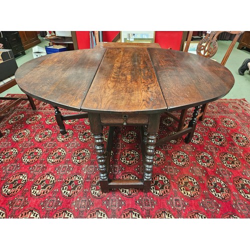 4126 - A Charles II pegged oak gate-leg oval top dining table, the rising leaves over two end drawers and b... 