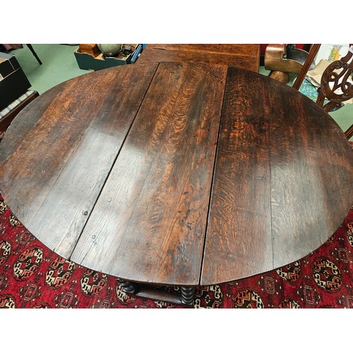 4126 - A Charles II pegged oak gate-leg oval top dining table, the rising leaves over two end drawers and b... 