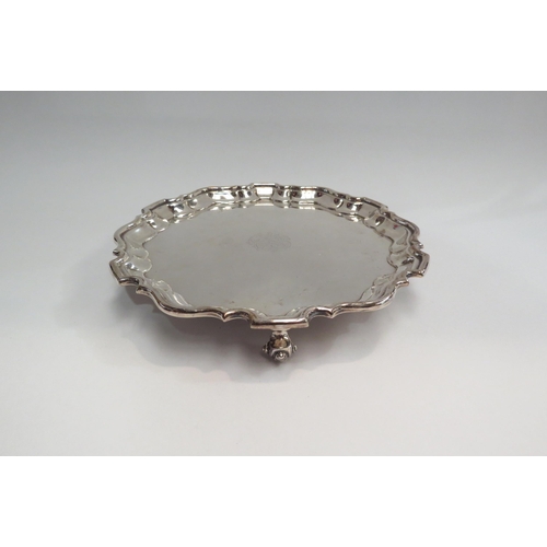 4346 - A George V silver salver, centred by a monogram, with piecrust rim and three gnarled feet.  Sheffiel... 