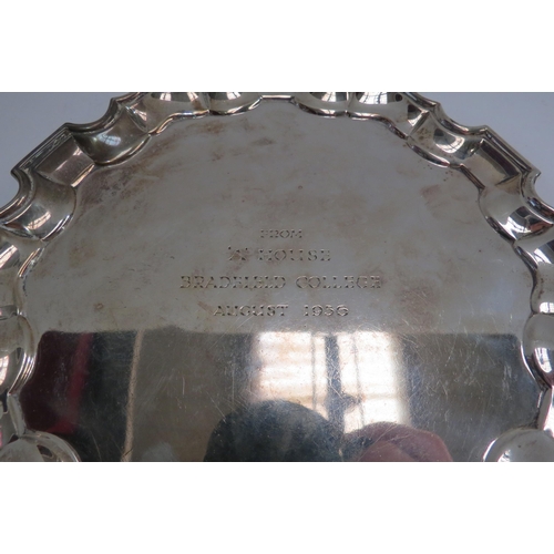 4356 - A George V silver waiter, with piecrust rim, on three gnarled feet, engraved with a presentation des... 