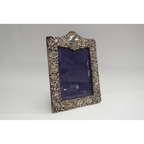 4360 - A late Victorian repousse silver photograph frame.  Birmingham 1899.  Worn, 21cm tall