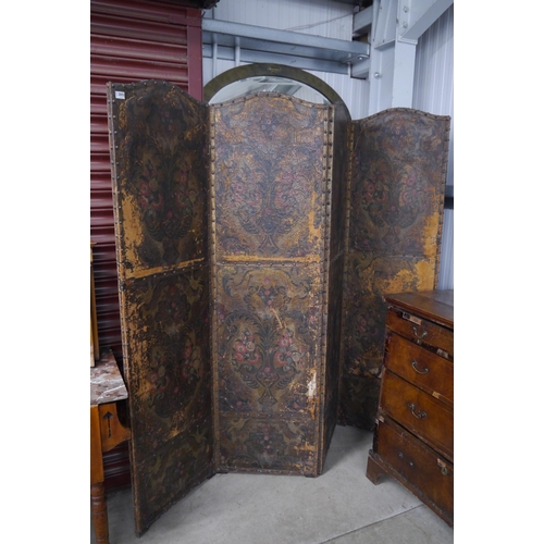 2111 - A distressed leather four panel screen, arch top, floral decoration, each panel 182cm x 52cm