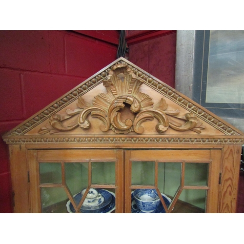 4217 - A George III country house stripped pine corner cabinet with carved decoration, the two astragal gla... 