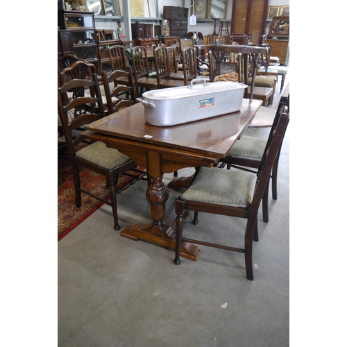 2212 - A 1940's oak draw leaf and four ladder back dining chairs