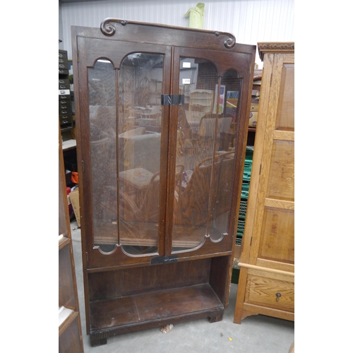 2328 - A 1940s oak glazed bookcase with moulded top