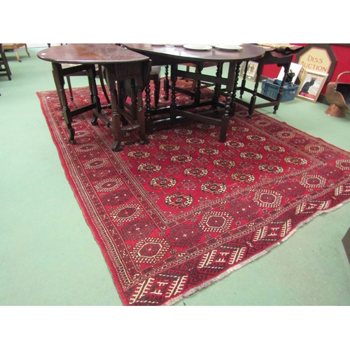 4492 - A Yomut Turkman red ground carpet, geometric design with multiple borders and tasselled ends, centra... 