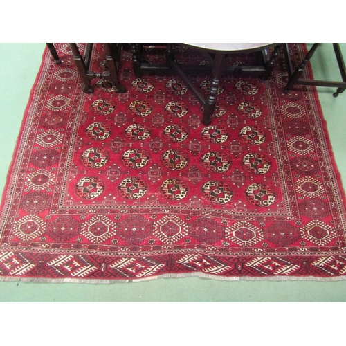 4492 - A Yomut Turkman red ground carpet, geometric design with multiple borders and tasselled ends, centra... 