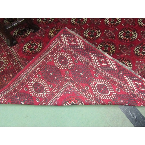 4492 - A Yomut Turkman red ground carpet, geometric design with multiple borders and tasselled ends, centra... 