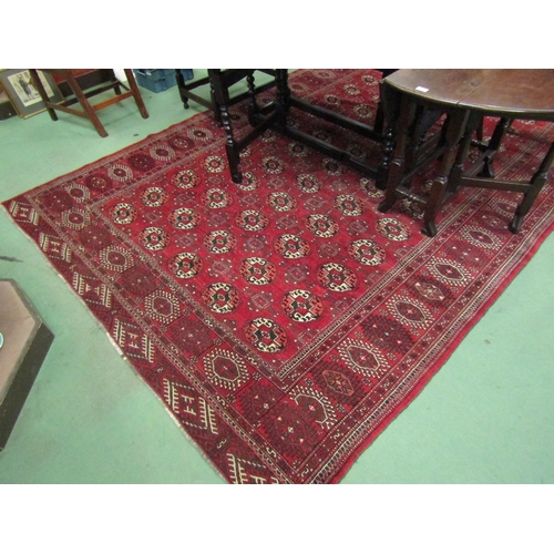 4492 - A Yomut Turkman red ground carpet, geometric design with multiple borders and tasselled ends, centra... 