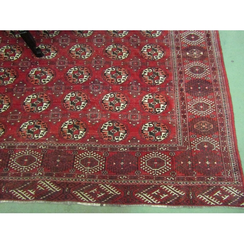 4492 - A Yomut Turkman red ground carpet, geometric design with multiple borders and tasselled ends, centra... 